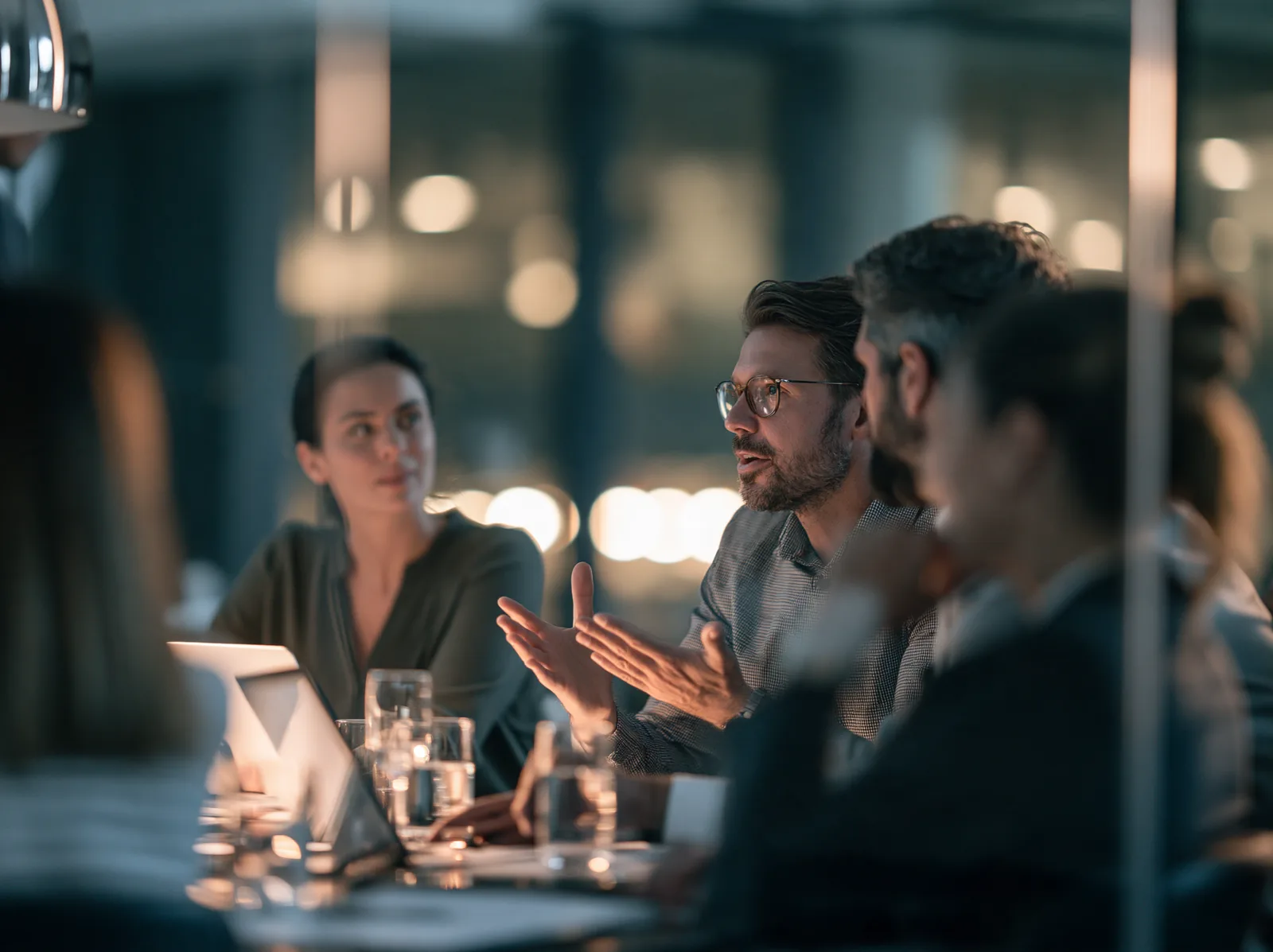 A team in conversation around a meeting table in the evening